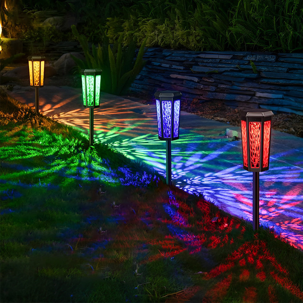 Solar stake light projecting multicolored leaf shadows on a garden path for a festive outdoor atmosphere.