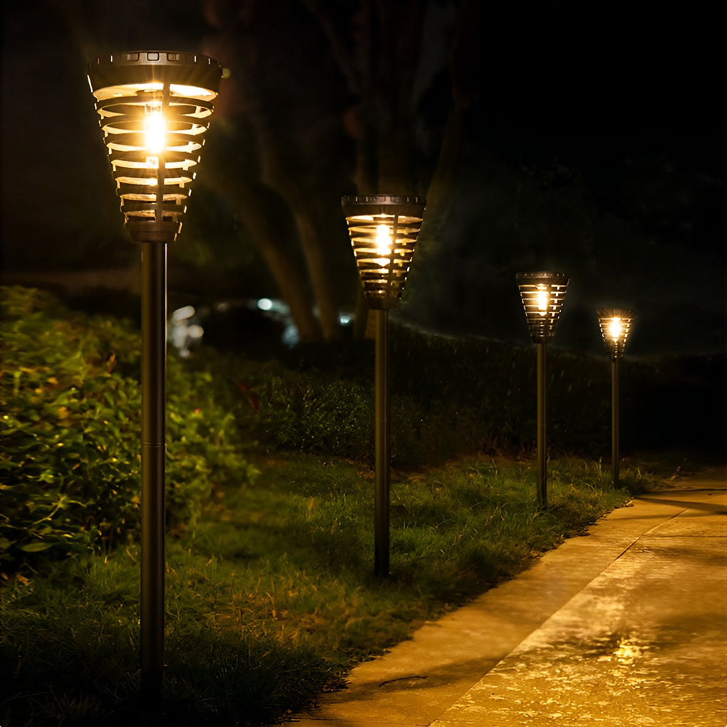 Solar torch light with a black finish, providing ambient light near a flower bed.