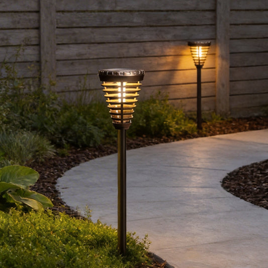 Solar torch light with a black finish, providing warm light along a wooden fence.