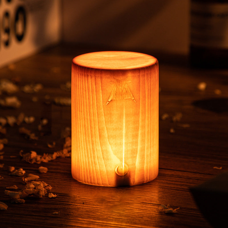 Square wood lamp casting a warm glow on a wooden table setup.